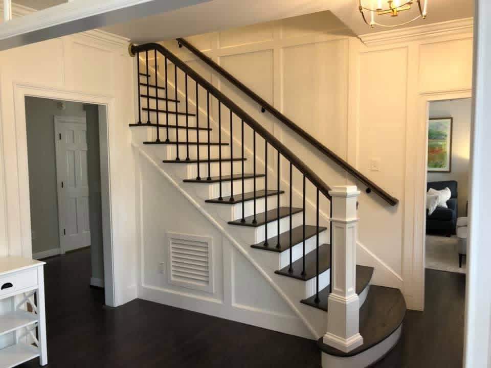 Finished staircase with bright white trim and dark treads